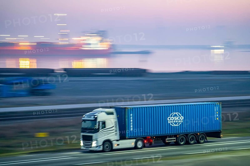Lorry on the road to Euromax Terminal Rotterdam, ENECO wind farm on the dike around the port of Maasvlakte 2, 22 wind turbines with a capacity of 116 megawatts, sunset, Rotterdam, Netherlands Cosco Container