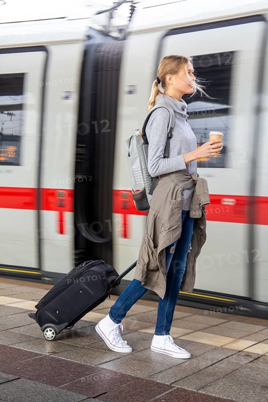 Young woman on the railway track while a train arrives
