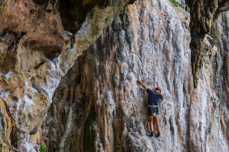 Rock climber at Phra Nang beach near Krabi, climber, outdoor, active holiday, climbing, rocks, chalk cliffs, sandstone cliffs, climbing, sport, sports holiday, rock climbing, height resistance, no fear of heights, courage, fear, overcoming fear, overcoming, extreme sportsman, extreme sport, safety, roping up, roped up, Thailand, Asia