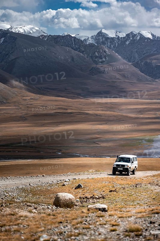 Off-road vehicle on a gravel track, glaciated and snow-covered peaks, Ak Shyrak Mountains, near Kumtor, Kara-Say, Tian Shan, Kyrgyzstan, Asia