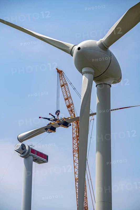 Erection of an Enercon E-160 wind turbine, rear, assembly of the first blade, 4 turbines with a total output of 22 megawatts replace 9 older wind turbines from the manufacturer Enercon (E-58 model series), front, they were in operation for over two decades, Lower Rhine, North Rhine-Westphalia, Germany, Europe