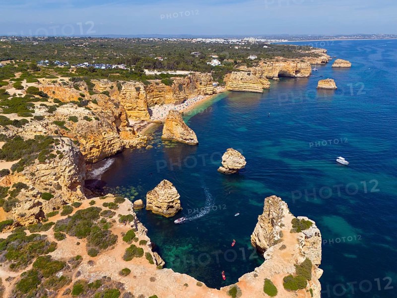 Aerial view of a rugged coastal landscape with rocky islands and boats in turquoise water, beach, Praia da Marinha, Lagoa, Rocky Algarve, Algarve, Portugal, Europe