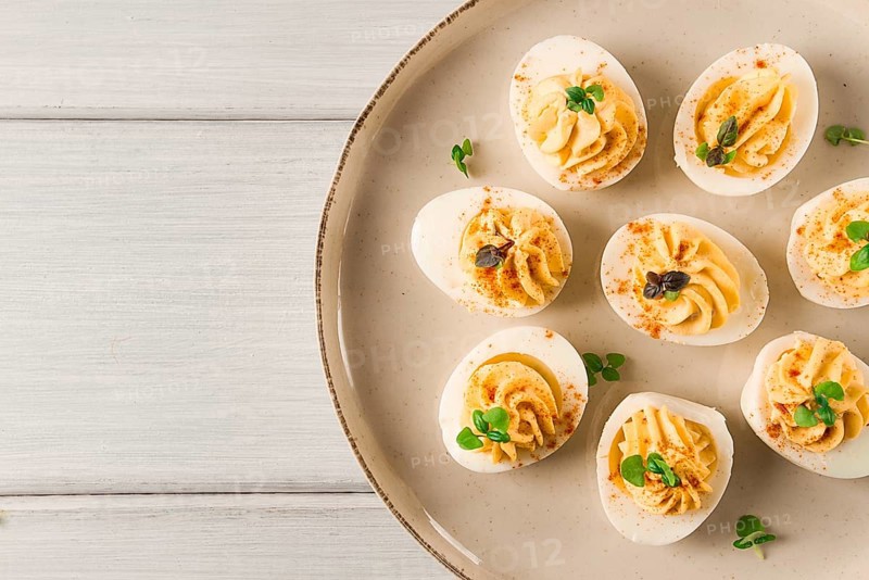 Boiled eggs stuffed with yolk with mayonnaise, on a white plate, selective focus, blurry, close-up, no people