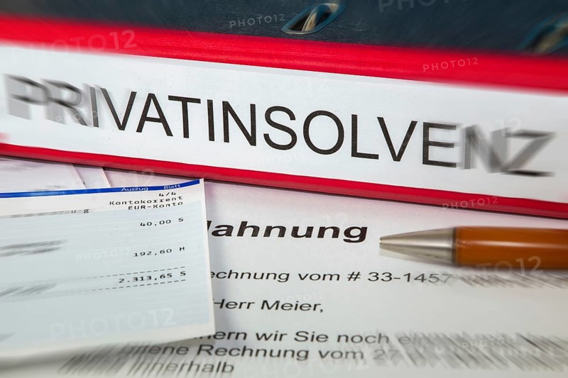 Symbolic image of personal insolvency: folder, bank statement and a reminder