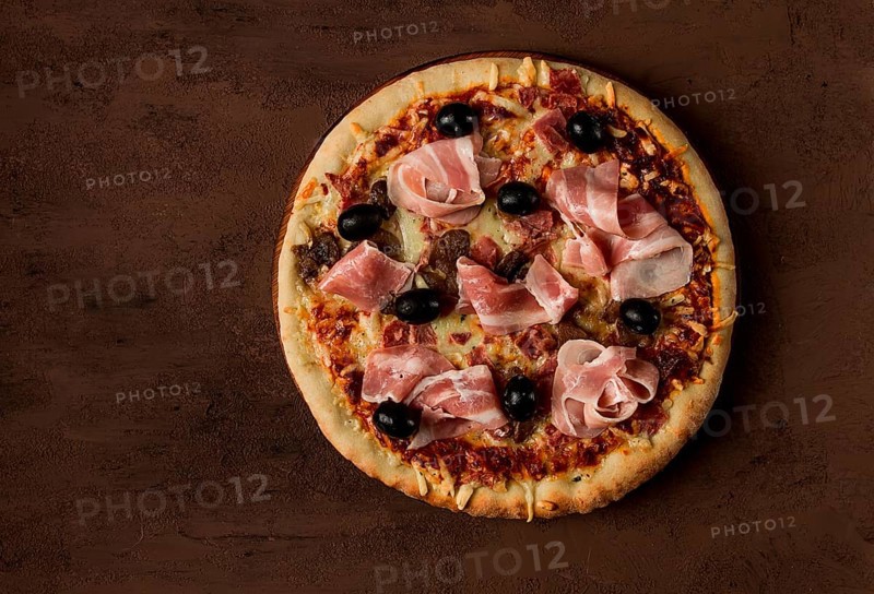 Pizza with prosciutto and mushrooms, bacon, olives, homemade, top view, no people