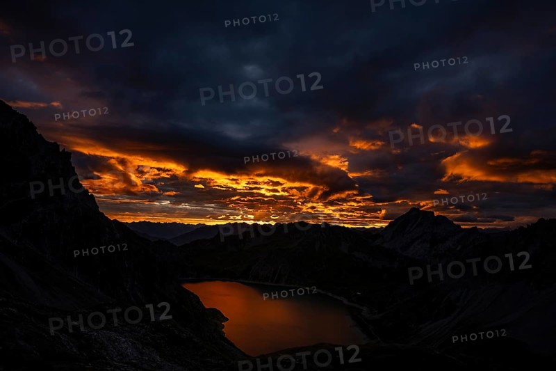Lake Lüner See with Montafon mountains and dramatic cloudy sky at sunrise, Tschagguns, Rätikon, Montafon, Vorarlberg, Austria, Europe