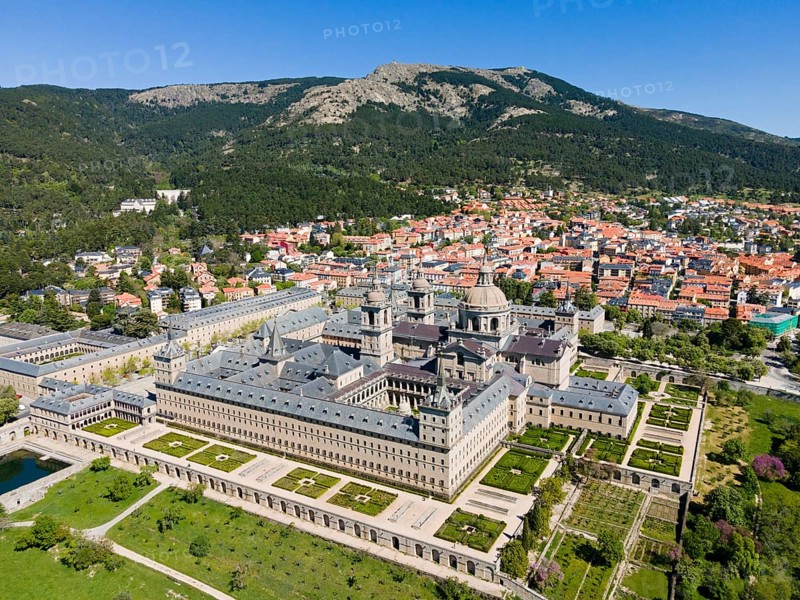 Historic monastery and neighbouring town, surrounded by green landscape and mountains, seen from the air, aerial view, Real Sitio de San Lorenzo de El Escorial, Royal Seat of Saint Lawrence of El Escorial, palace and monastery complex, San Lorenzo de El Escorial, Madrid, Spain, UNESCO World Heritage Site, Europe