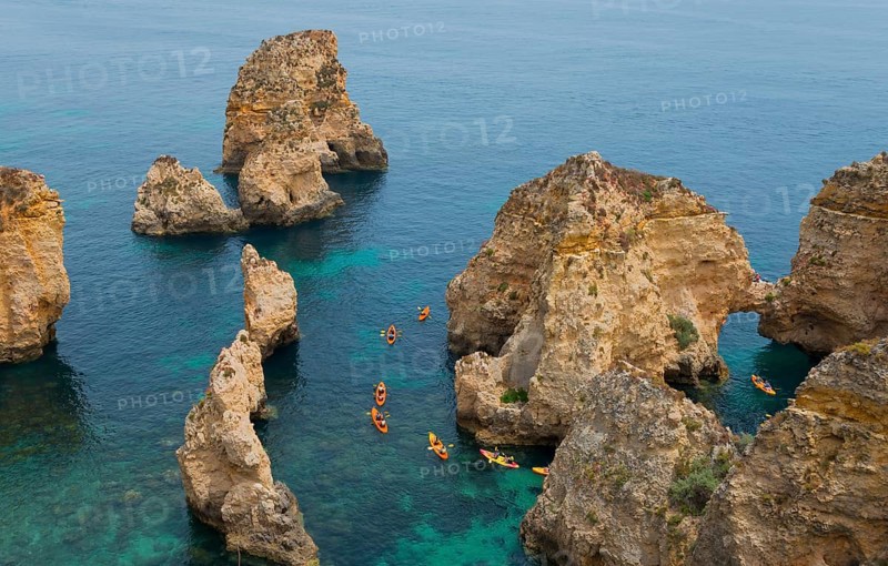 Kayakers explore the steep cliffs and coastline on the clear blue sea, Ponta da Piedade, point of mercy, Lagos, Algarve, Portugal, Europe