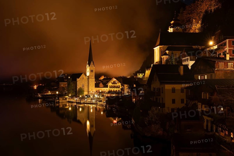 View of Hallstatt with the church and Lake Hallstatt at night. Clouds move through Hallstatt. Reflection. Hallstatt, Gmunden, Salzkammergut, Upper Austria, Austria, Europe