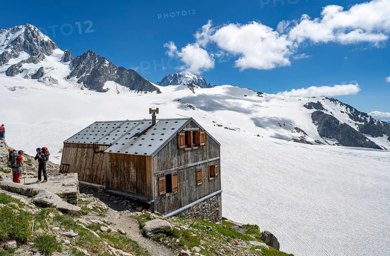 Mountaineer next to a mountain hut in front of a mountain landscape, Former hut of the mountain hut Refuge Albert 1er, Glacier du Tour, Glacier and mountain peaks, High alpine landscape, left Tête Blanche, Petite and Grande Fourche, right Alguille de Chardonnet, Chamonix, Haute-Savoie, France, Europe