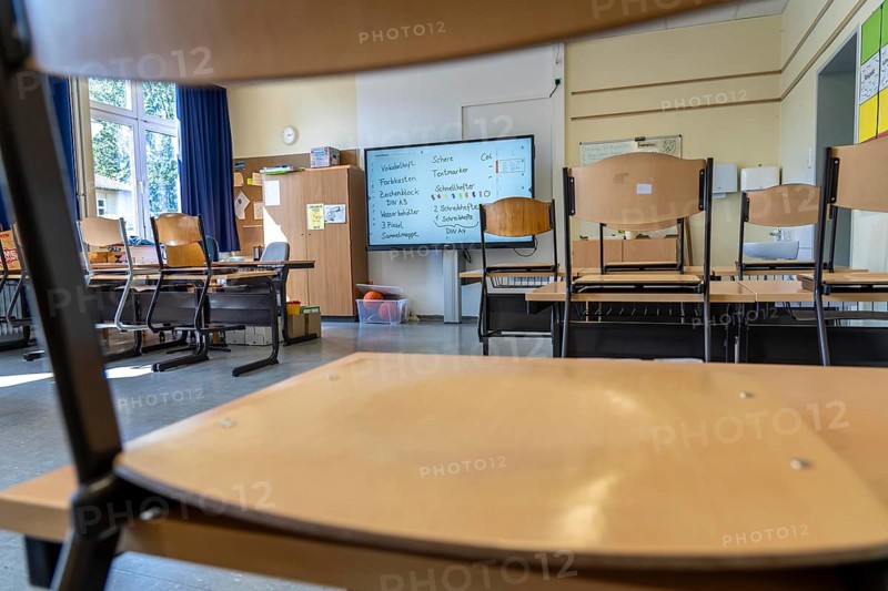Classroom of a fourth grade, after school, the building is older but in good condition, modern teaching materials, interactive, digital whiteboard