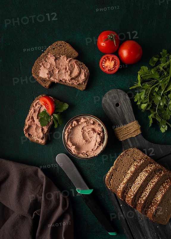 Liver meat pate spread on rye bread, breakfast, close-up, dark background. no people, selective focus