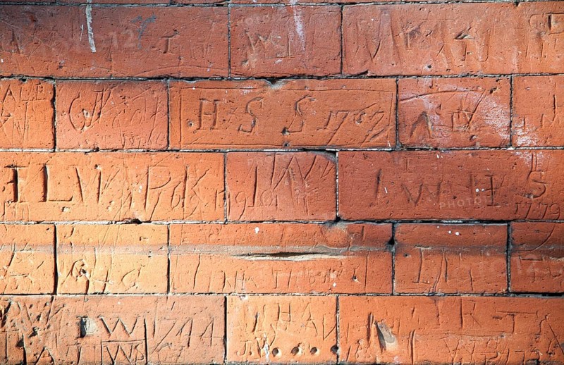 Eighteenth century children's graffiti scratched into red brick of former school building, Dedham, Essex, England, United Kingdom, Europe