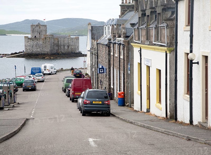 General view of the main shopping street in Castlebay the largest settlement in Barra, Outer Hebrides, Scotland, UK looking to Kisimul castle in the bay