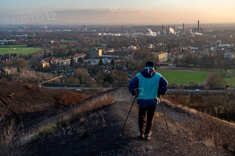 Walker on the Rungenberg slagheap, view to the south, A2 motorway, Ruhr Öl GmbH refinery in Gelsenkirchen Horst, Gelsenkirchen, North Rhine-Westphalia, Germany, Europe