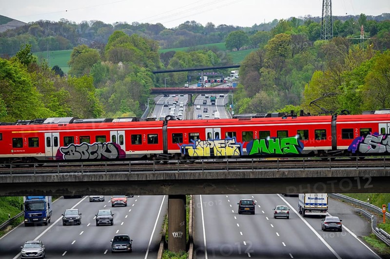S-Bahn train crossing the motorway A3, traffic on 8 lanes, incl. the temporarily released hard shoulder, behind the motorway junction Hilden, view in north direction, near Erkrath, North Rhine-Westphalia, Germany, Europe