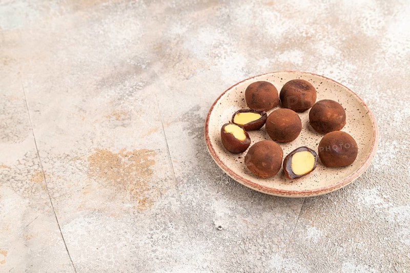 Japanese rice sweet buns chocolate mochi filled with cream on brown concrete background. side view, copy space