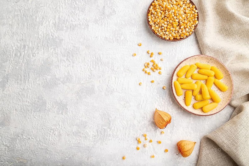 Jelly corn candies on gray concrete background and linen textile. top view, flat lay, copy space