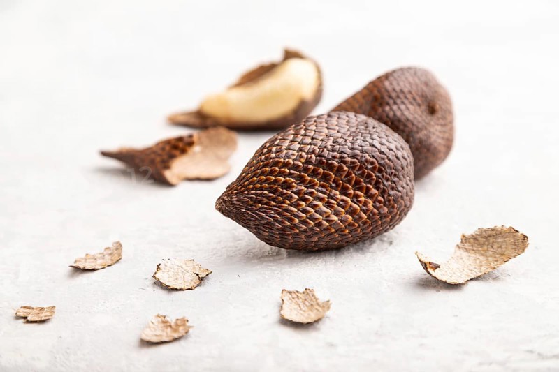 Salak or snake fruit on gray concrete background. Side view, close up, selective focus. Tropical, healthy food, summer, exotic, minimalism