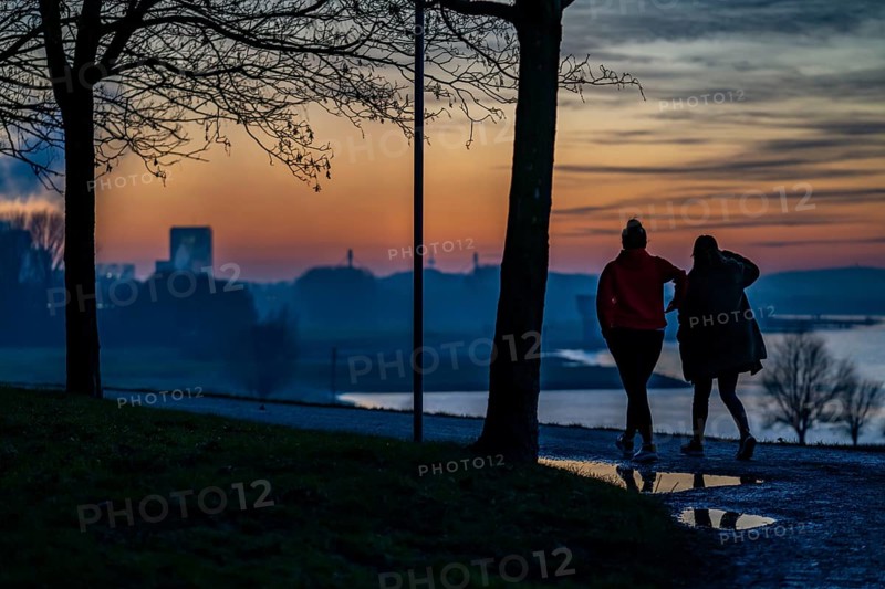 Rhine near Duisburg-Bruckhausen, walkers on the Rhine dyke, winter, Duisburg, North Rhine-Westphalia, Germany, Europe