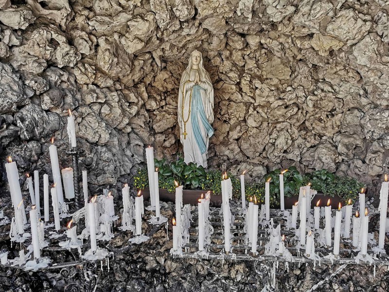Statue of the Virgin Mary in front of a rock background surrounded by burning and burnt down candles, Mariengrotte at the pilgrimage church, Gößweinstein, place of pilgrimage in Franconian Switzerland, district of Forchheim, Upper Franconia, Bavaria, Germany, Europe