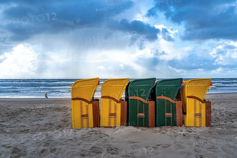End of the season on the beach, dark storm clouds, choppy sea, autumn on the North Sea in North Holland, near Egmond aan Zee, beach chairs ready for transport to winter storage, Netherlands