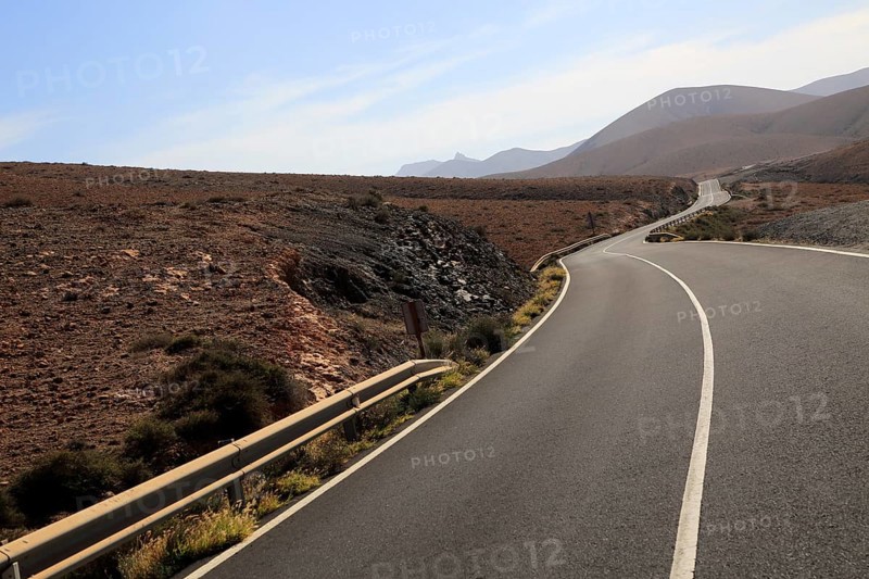Tarmac road crossing barren desert mountainous land between Pajara and La Pared, Fuerteventura, Canary Islands, Spain, Europe