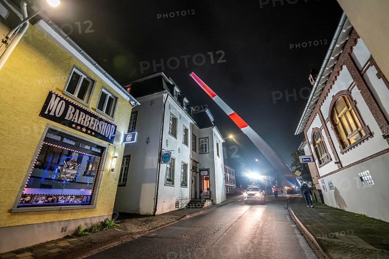 Transport of a 68 metre long, 22 tonne blade of a wind turbine, here in Breckerfeld, with a self-propelled Blade-Lifter vehicle, over a 40 km long route, over 2 nights, in the Bergisches Land, through towns, villages, over country roads, narrow through roads, to the construction site of the wind turbine near Hagen, North Rhine-Westphalia, Germany, Europe