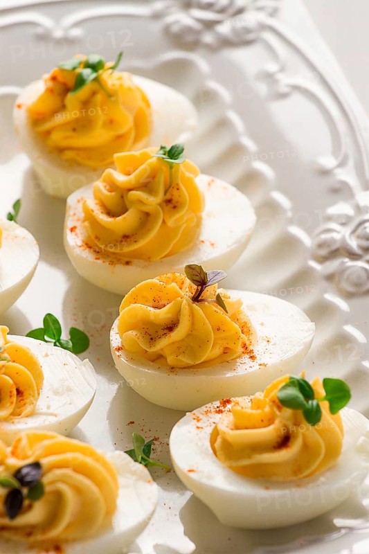 Boiled eggs stuffed with yolk with mayonnaise, on a white plate, selective focus, blurry, close-up, no people