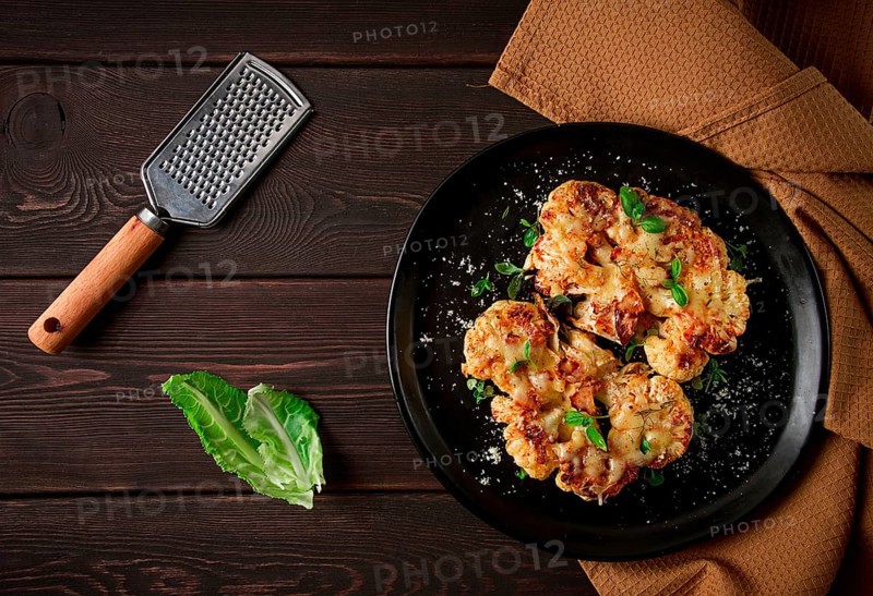 Steak, cauliflower, with cheese, spices, homemade, on a wooden table, dark background, close-up, top view, selective focus, no people
