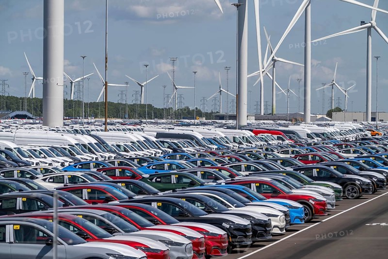 Storage area for new cars in the port of Vlissingen-Oost, vehicles are temporarily stored on over 100 hectares to ship them from Europe to the United Kingdom, Ford cars, others such as models from the Chinese car manufacturer BYD are delivered from here in Europe, wind farm, Netherlands