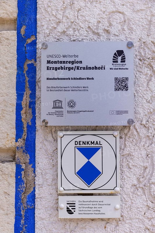 Schindler's blue colour factory is located directly on the Zwickauer Mulde river and belongs to the Zschorlau district of Albernau in the Saxon Ore Mountains. Since 2019, it has been part of the Schneeberg Mining Landscape and a UNESCO World Heritage Site in the Erzgebirge/Krušnohorí Mining Region. On 27 February 1649, the Schneeberg merchant Erasmus Schindler bought a plot of land to build a blue paint factory on the Zwickauer Mulde near Albernau. On 4 May 1649, he received the privilege to build a blue dye mill from Elector Johann Georg I. As Schindlerswerk GmbH & Co. KG, it is probably the world's oldest paint factory still in production. It is associated with a long tradition of producing blue cobalt pigments and the commercial manufacture of colour pigments. In more recent times, production has been expanded to include various paints. Laundry blue is also produced. UNESCO plaque for Schindler's blue paint factory, Schindlerswerk, Zschorlau OT Albernau, Saxony, Germany, Europe