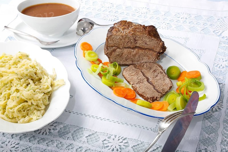 Swabian cuisine, roast beef, roast ox, herb spaetzle, meat dish, gravy, carrot vegetables, leek, serving platters, hearty, savoury, typical Swabian, home cooking, traditional cuisine, food photography, studio, Germany, Europe