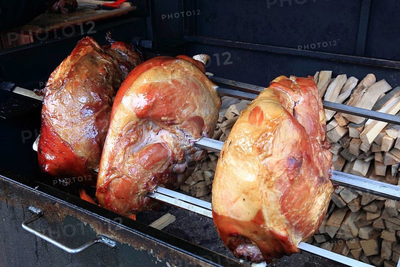Pork knuckles are grilled on a spit over a wood fire, a speciality in Prague, Czech Republic, Europe