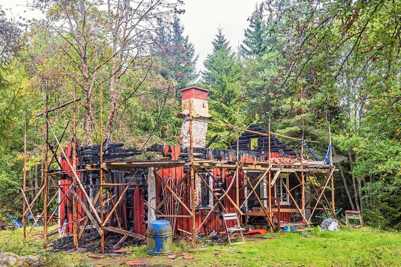 Wooden cottage that has burned down in the woodland, Sweden, Europe