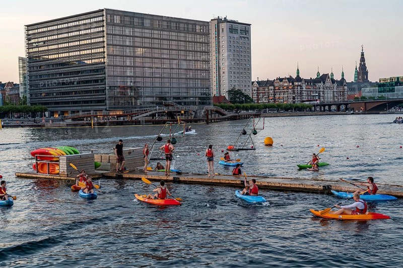 Summer evening in Copenhagen, at the harbour, Islands Brygge, people celebrating, eating, drinking, relaxing at the harbour shore, kayak polo, Denmark, Europe