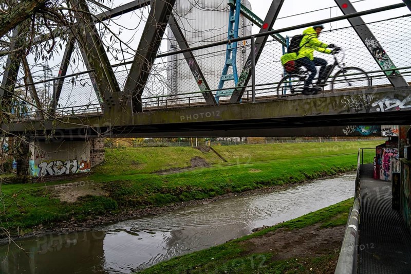 The River Emscher, sewage river, old railway bridge, now a footpath and cycle path, bridge for local buses and trams, in Oberhausen, North Rhine-Westphalia, Germany, Europe