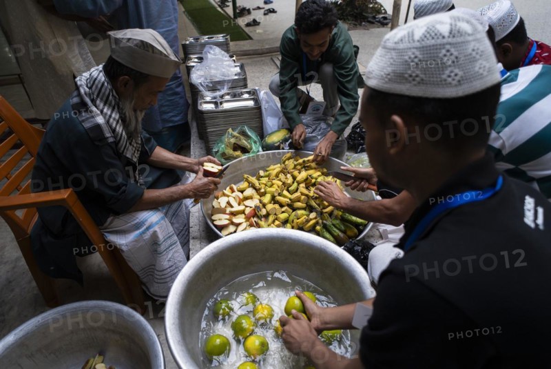 Muslim people cuts fruits to distribute during 'iftar' meal, to break their fast during the holy month of Ramadan, at Burha Jame Masjid, at Burha Jame Masjid, on March 13, 2024 in Guwahati, Assam, India, Asia