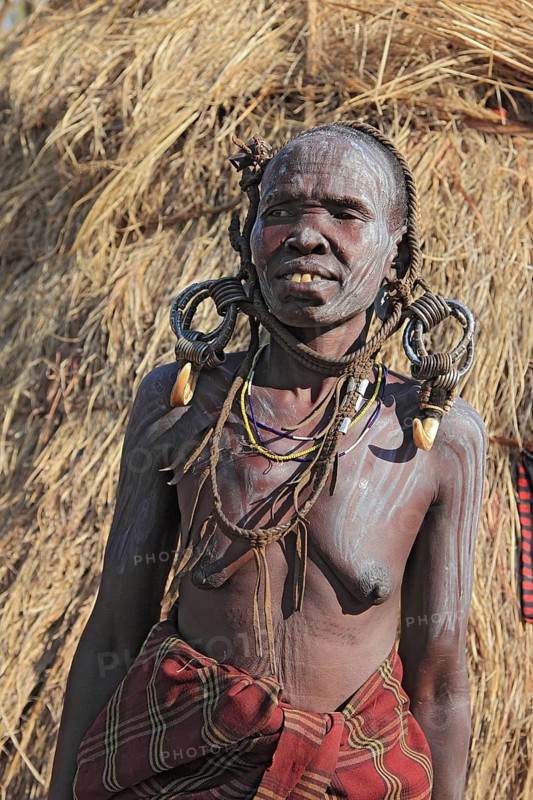 South Ethiopia, in the Maco National Park, Mursi tribe, older Mursi woman with naked upper body and painted skin and earrings, Ethiopia, Africa