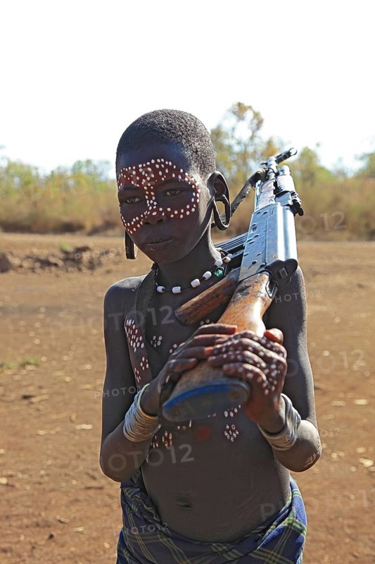 South Ethiopia, in Maco National Park, Mursi tribe, Mursi boy with painted face and rifle, Ethiopia, Africa