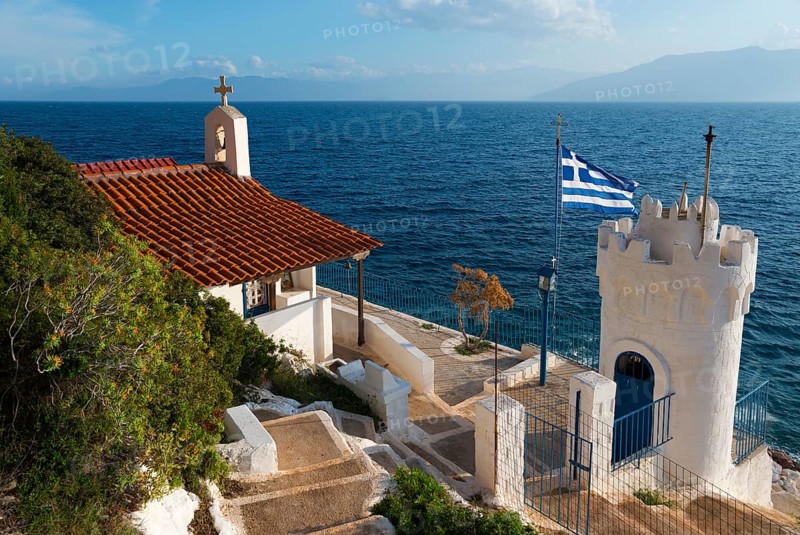 Small chapel on the coast with a view of the sea and a Greek flag, Church of Agios Nikolaos Krasoktistos, Agia Kyriaki, Nafplio, Nauplia, Nauplion, Nafplion, Argolis, Argolic Gulf, Peloponnese, Greece, Europe