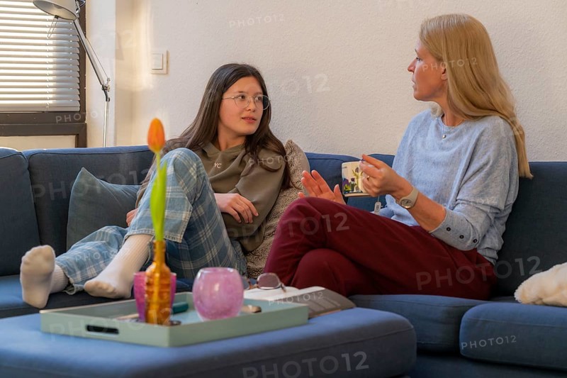 Mother and daughter, teenage, 13 years old, in a confidential conversation, at home