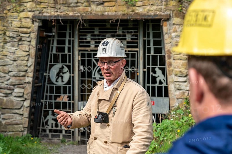 Visitor group at the entrance to the Nachtigallstollen, tour guide, GeoRoute Ruhr, Dünkelberg quarry, in the Muttental valley, here you can see the geology of the region, a thin coal seam is visible, underneath were thicker layers of coal that were mined, Witten, North Rhine-Westphalia, Germany, Europe