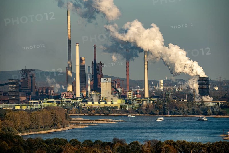 Rhine near Duisburg Bruckhausen, Thyssenkrupp Steel steelworks, blast furnaces, sintering plant, Schwelgern coking plant, discharge cloud, cargo ships, North Rhine-Westphalia, Germany, Europe