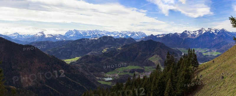 Panoramic view of the snow-covered Chiemgau mountains and green hills above the village of Unterwössen in the Chiemgau Alps Bavaria Germany Europe