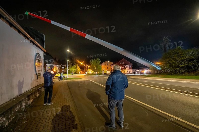 Transport of a 68 metre long, 22 tonne blade of a wind turbine, here in Schwelm, onlookers, with a self-propelled Blade-Lifter vehicle, over a 40 km long route, over 2 nights, in the Bergisches Land, through towns, villages, over country roads, narrow through roads, to the construction site of the wind turbine near Hagen, North Rhine-Westphalia, Germany, Europe