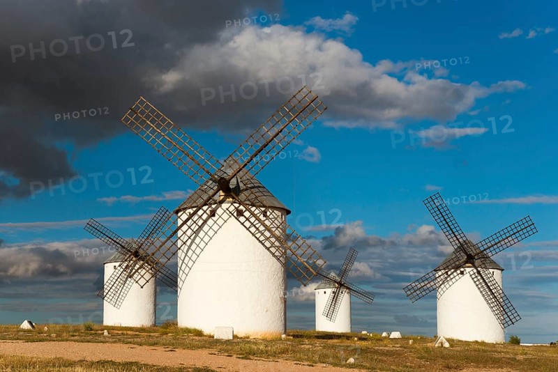 Windmills in a vast landscape under a sky with dramatic clouds and sunlight, Windmills, Campo de Criptana, Ciudad Real province, Castilla-La Mancha, Route of Don Quixote, Spain, Europe
