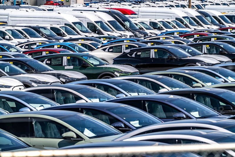 Storage area for new cars in the port of Vlissingen-Oost, vehicles are temporarily stored on over 100 hectares to ship them from Europe to the United Kingdom, Ford cars, others such as models from the Chinese car manufacturer BYD are delivered from here in Europe, wind farm, Netherlands