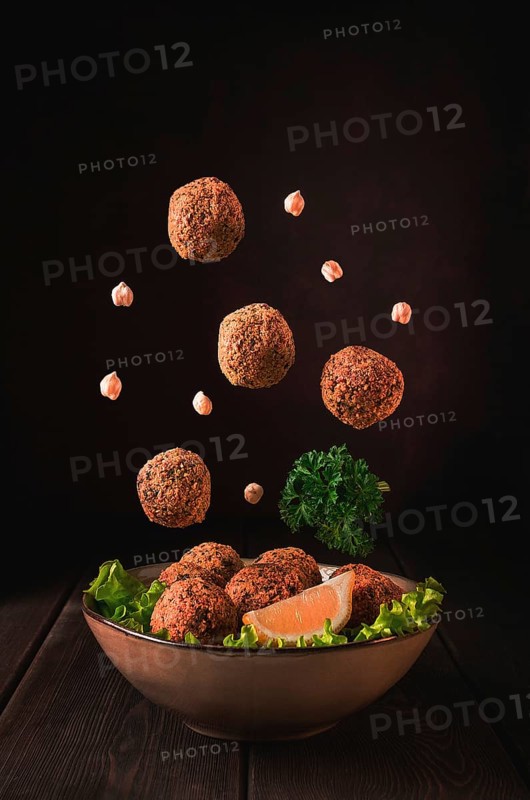 Chickpea falafel balls, on a wooden table, close-up, vegetarian food, levitation, vertical