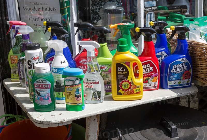 Display of various garden products in plastic spray containers outside hardware store, Woodbridge, Suffolk, England, UK